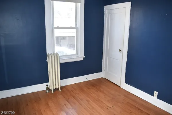 an empty room with wooden floor and window