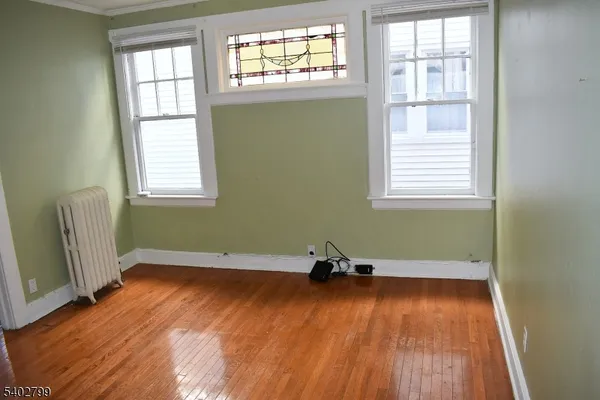 an empty room with wooden floors and windows