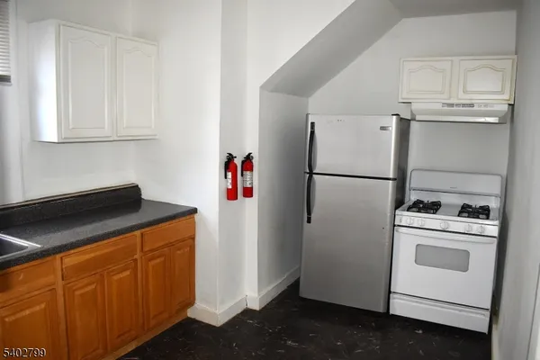 a kitchen with a refrigerator stove and white cabinets