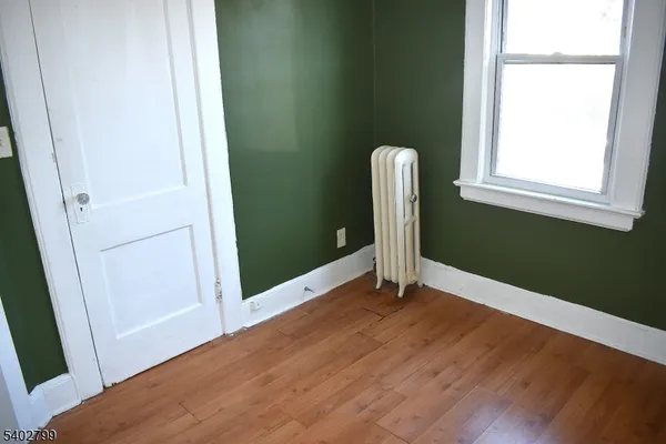 a view of a room with wooden floor and a window