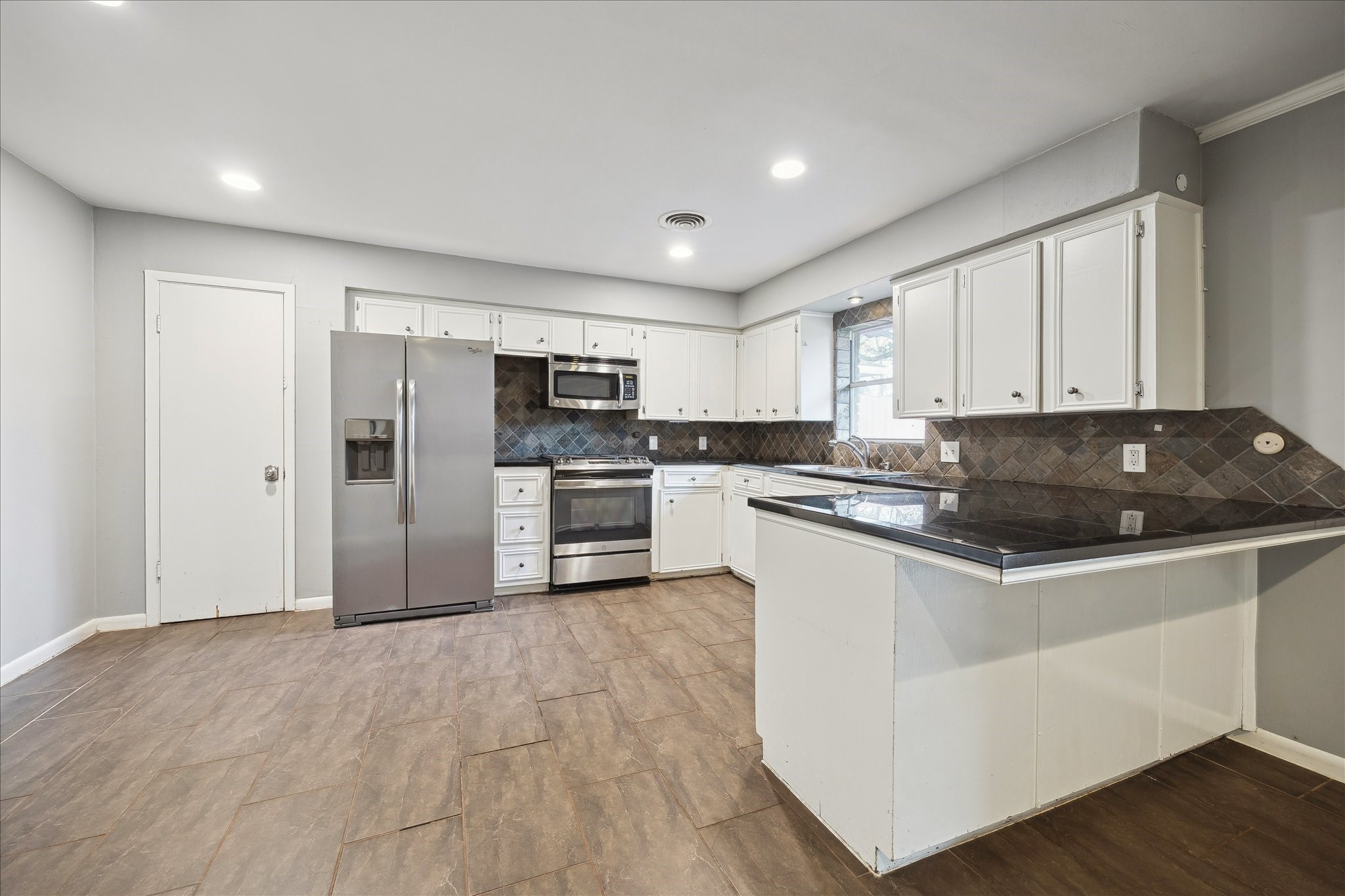 11519 Endicott Lane Houston, TX 77035 - Photo 8 of 25 a kitchen with granite countertop a refrigerator and a stove top oven