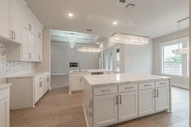 a open kitchen with white cabinets and stainless steel appliances