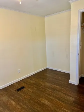 a view of an empty room with wooden floor