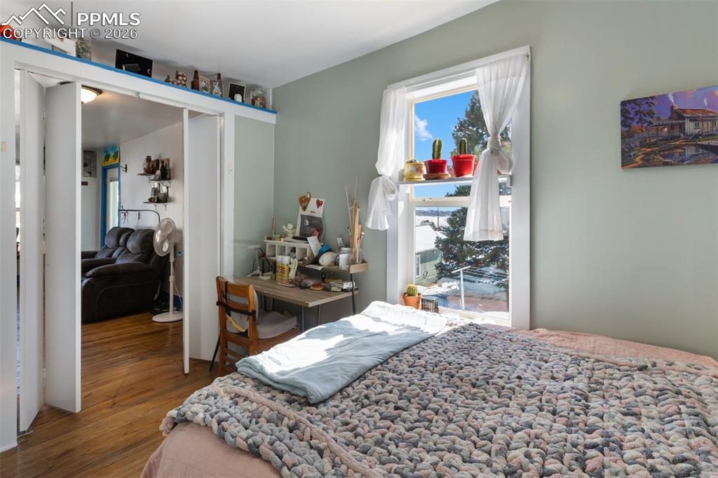 209 5th Street Victor, CO 80860 - Photo 21 of 36 a bedroom with a bed and wooden floor