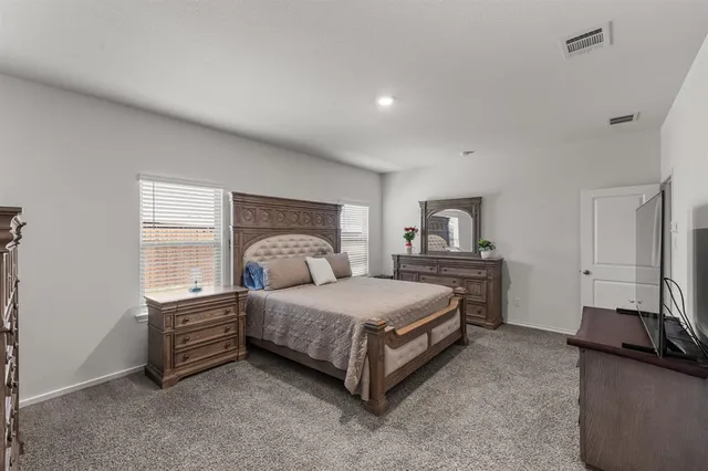 a spacious bedroom with a bed and a window