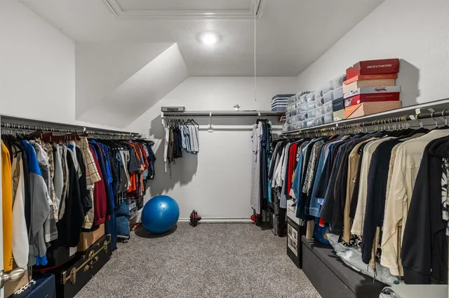 a view of walk in closet with clothes and shoes