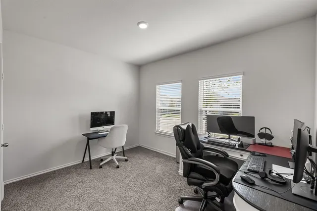 a view of a workspace with furniture and a window