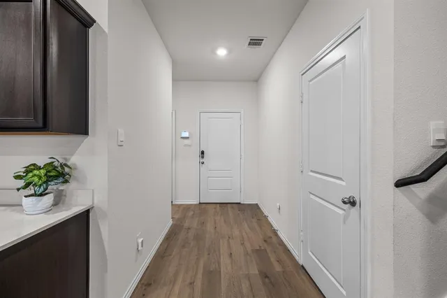 a view of a hallway with wooden floor and glass door
