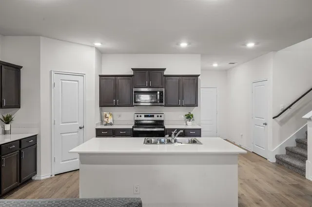 a kitchen with stainless steel appliances a sink stove and refrigerator