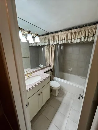 a bathroom with a granite countertop sink a toilet and bathtub