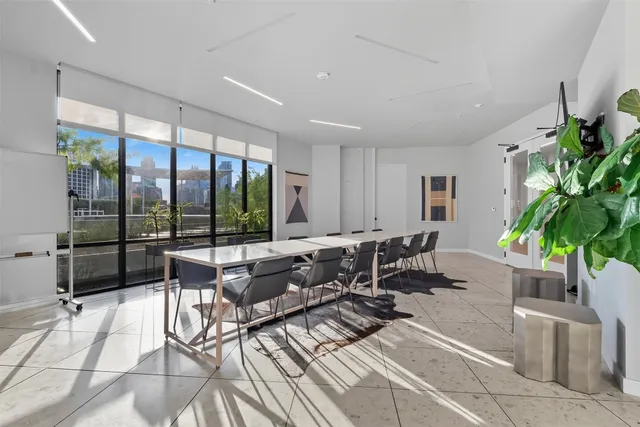 a living room with furniture potted plant and a large window