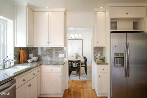 a kitchen with stainless steel appliances granite countertop a refrigerator and a stove top oven