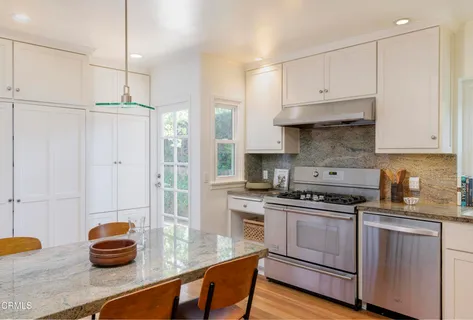 a kitchen with white cabinets and appliances