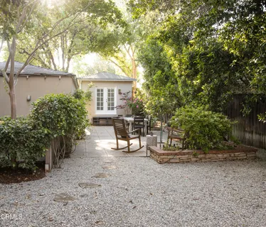 a view of house with backyard and a tree