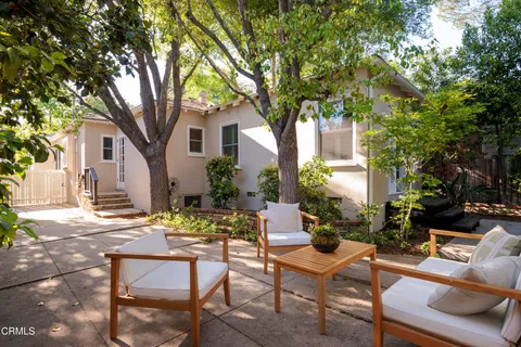 a view of a house with backyard and sitting area