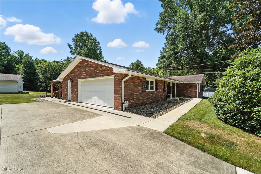 2930 South Ridge Road East Kingsville, OH 44048 - Photo 2 of 49 View of front of property featuring brick siding, driveway, a front lawn, and an attached garage