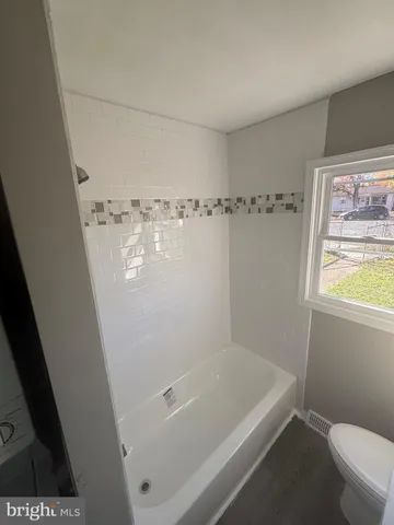 a bath tub sitting next to a white toilet and a sink