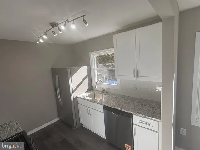 a kitchen with stainless steel appliances granite countertop a sink a stove and a refrigerator