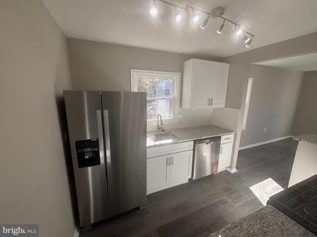 a kitchen with stainless steel appliances granite countertop a refrigerator and a sink