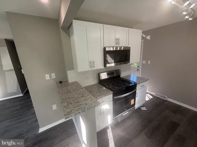 a kitchen with granite countertop a stove and a sink