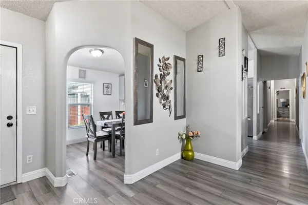 a kitchen with stainless steel appliances granite countertop a stove top oven a sink a dining table and chairs with white cabinets