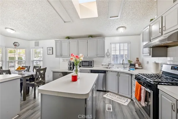 a kitchen with kitchen island a stove cabinets and wooden floor