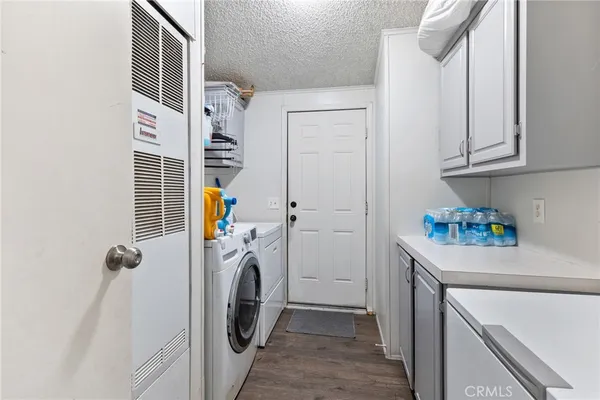 a view of a hallway with wooden floor and cabinets