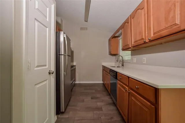 a kitchen with stainless steel appliances granite countertop a refrigerator and a sink