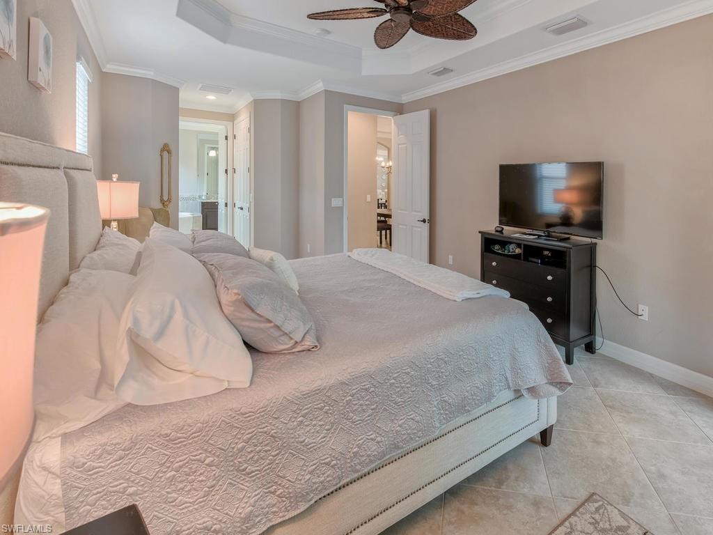 9491 Piacere Way Naples, FL 34113 - Photo 12 of 34 a bedroom with a bed and a flat screen tv