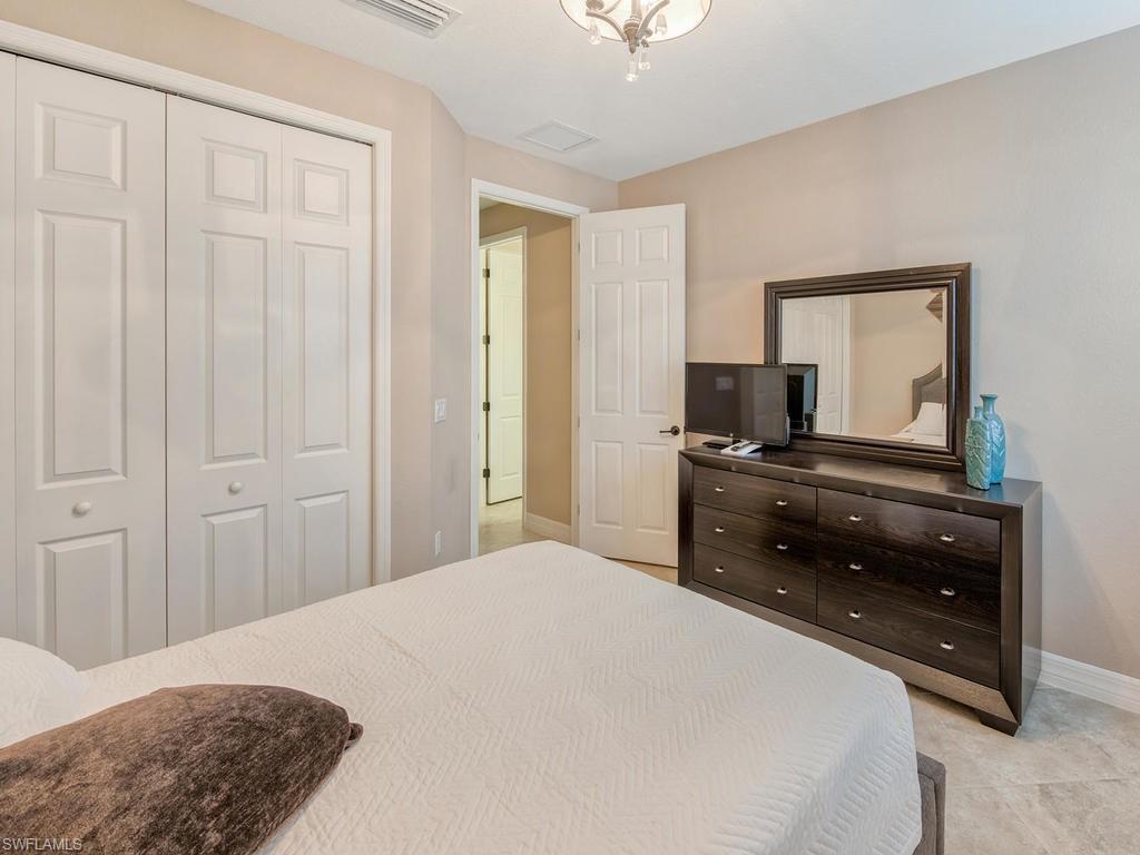 9491 Piacere Way Naples, FL 34113 - Photo 18 of 34 a bedroom with a bed and a dresser