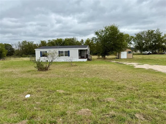 a view of a house with a yard and trees