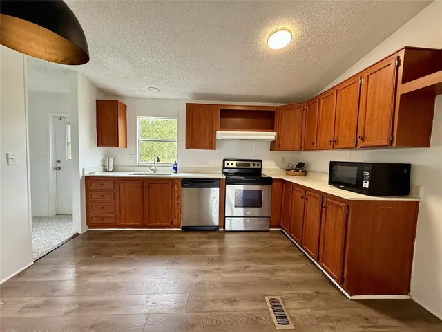 a kitchen with stainless steel appliances granite countertop a stove a sink and a refrigerator