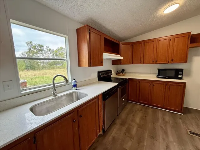 a kitchen with a sink stove top oven and cabinets