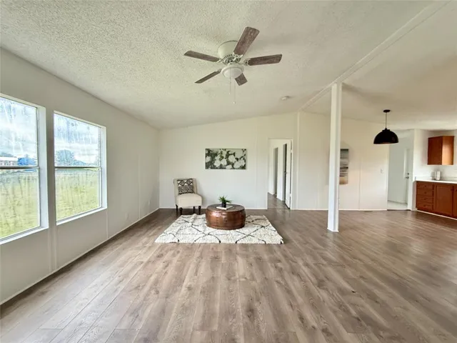 a view of a livingroom with wooden floor and a ceiling fan