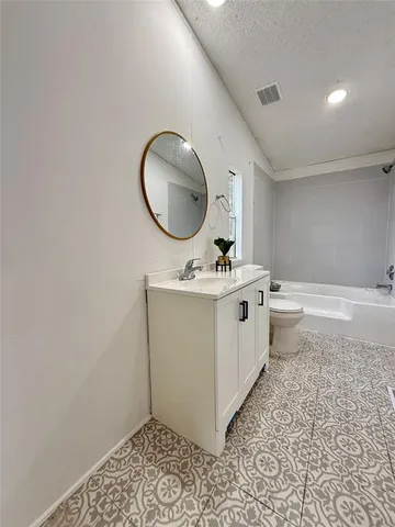 a bathroom with a sink mirror vanity and toilet