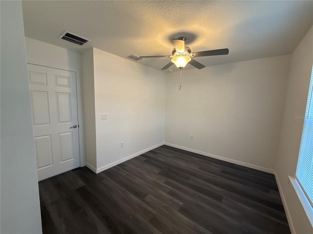 2234 Northwest 65th Place Ocala, FL 34475 - Photo 19 of 36 an empty room with wooden floor fan and windows
