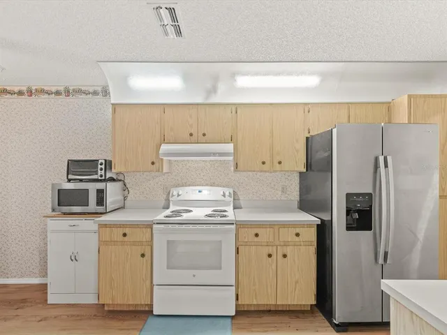a kitchen with a stove cabinets and refrigerator