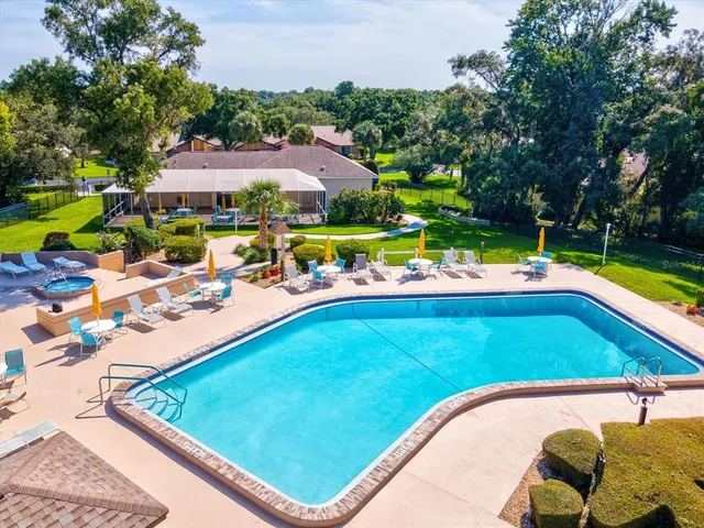 a view of a table and chairs under an umbrella in front of house
