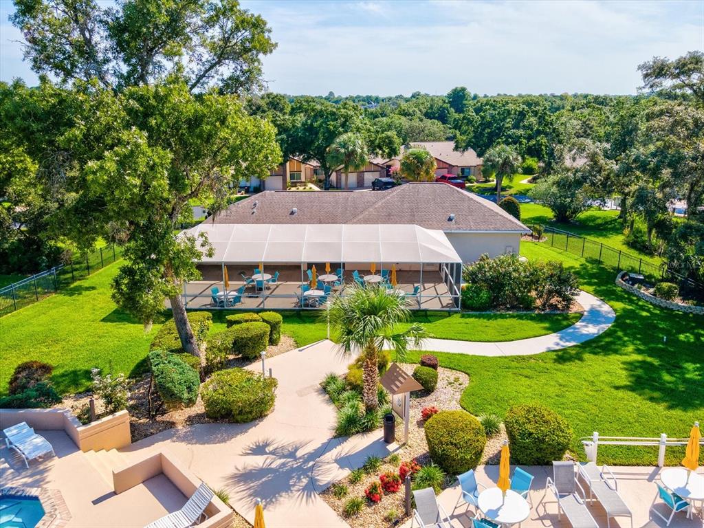 7415 Heather Walk Drive Weeki Wachee, FL 34613 - Photo 30 of 35 a view of a table and chairs under an umbrella in front of house