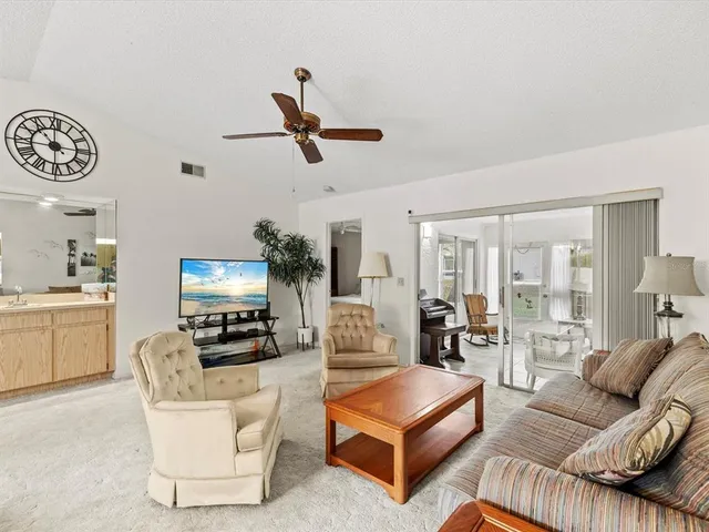 a living room with furniture a ceiling fan and a window