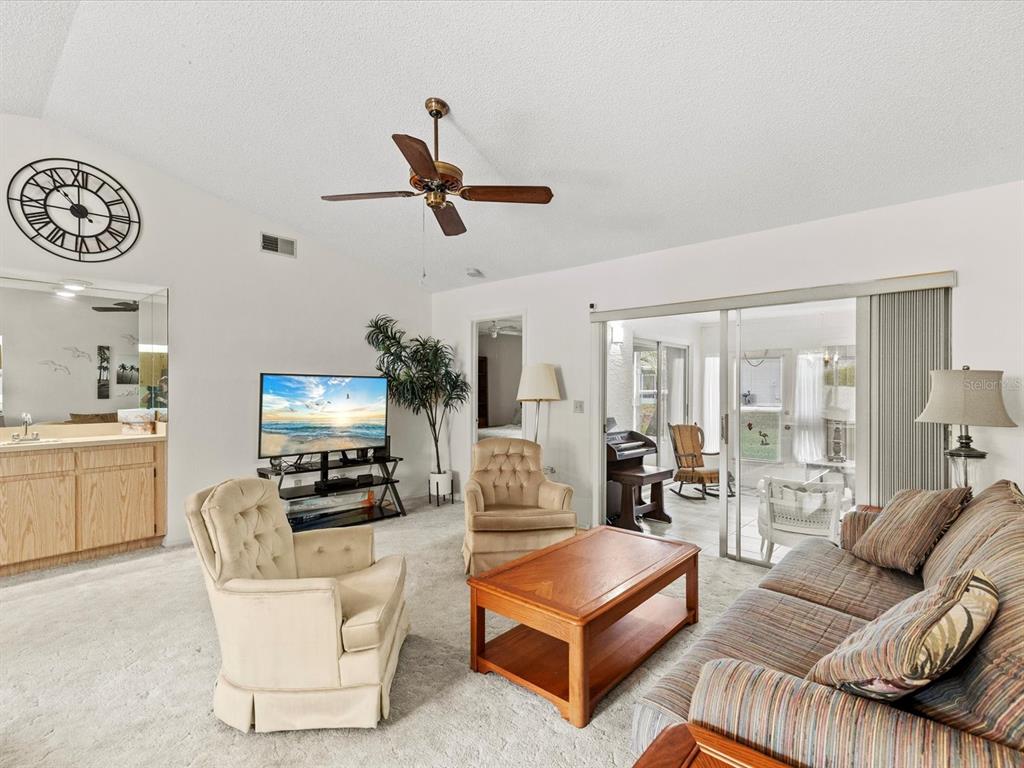 7415 Heather Walk Drive Weeki Wachee, FL 34613 - Photo 10 of 35 a living room with furniture a ceiling fan and a window