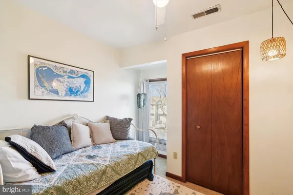 a living room with a bed and a painting on the wall