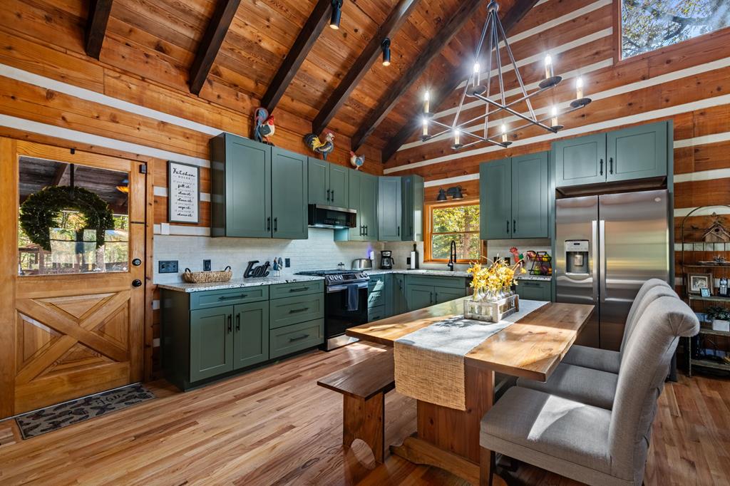 212 Dogpatch Lane Blue Ridge, GA 30513 - Photo 14 of 70 a kitchen with stainless steel appliances kitchen island granite countertop a table chairs and a wooden cabinets