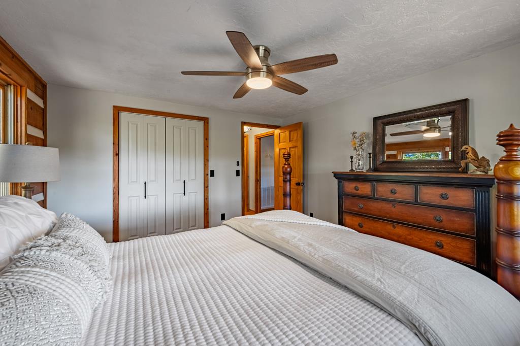 212 Dogpatch Lane Blue Ridge, GA 30513 - Photo 22 of 70 a bedroom with a bed and a chandelier