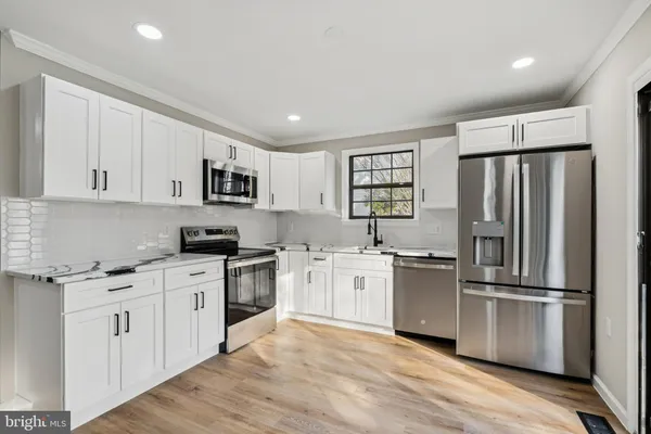 a kitchen with stainless steel appliances granite countertop a refrigerator stove and sink