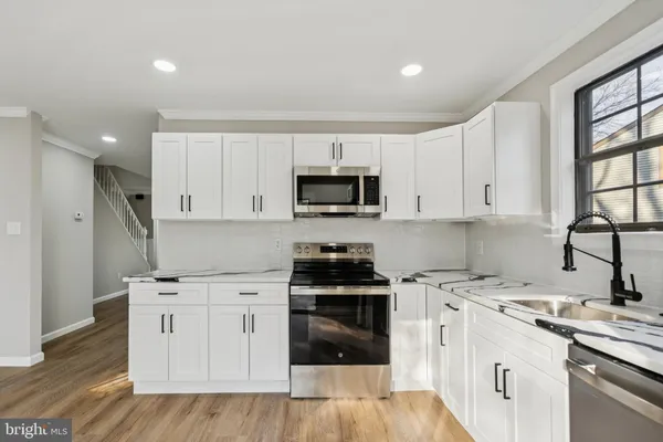 a kitchen with white cabinets and appliances