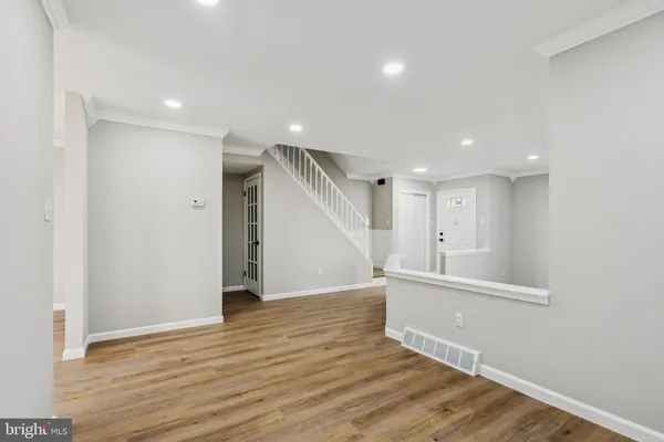 a view of an empty room with wooden floor and entryway