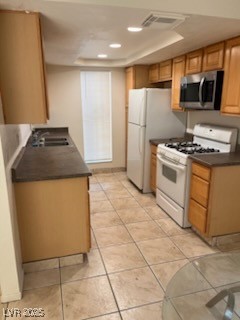 1440 East Vegas Valley Drive, Unit 7 Las Vegas, NV 89169 - Photo 15 of 19 Kitchen featuring white gas range oven, dark countertops, stainless steel microwave, recessed lighting, and light tile patterned flooring