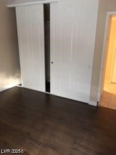 1440 East Vegas Valley Drive, Unit 7 Las Vegas, NV 89169 - Photo 7 of 19 Unfurnished bedroom featuring a closet and dark wood-style floors