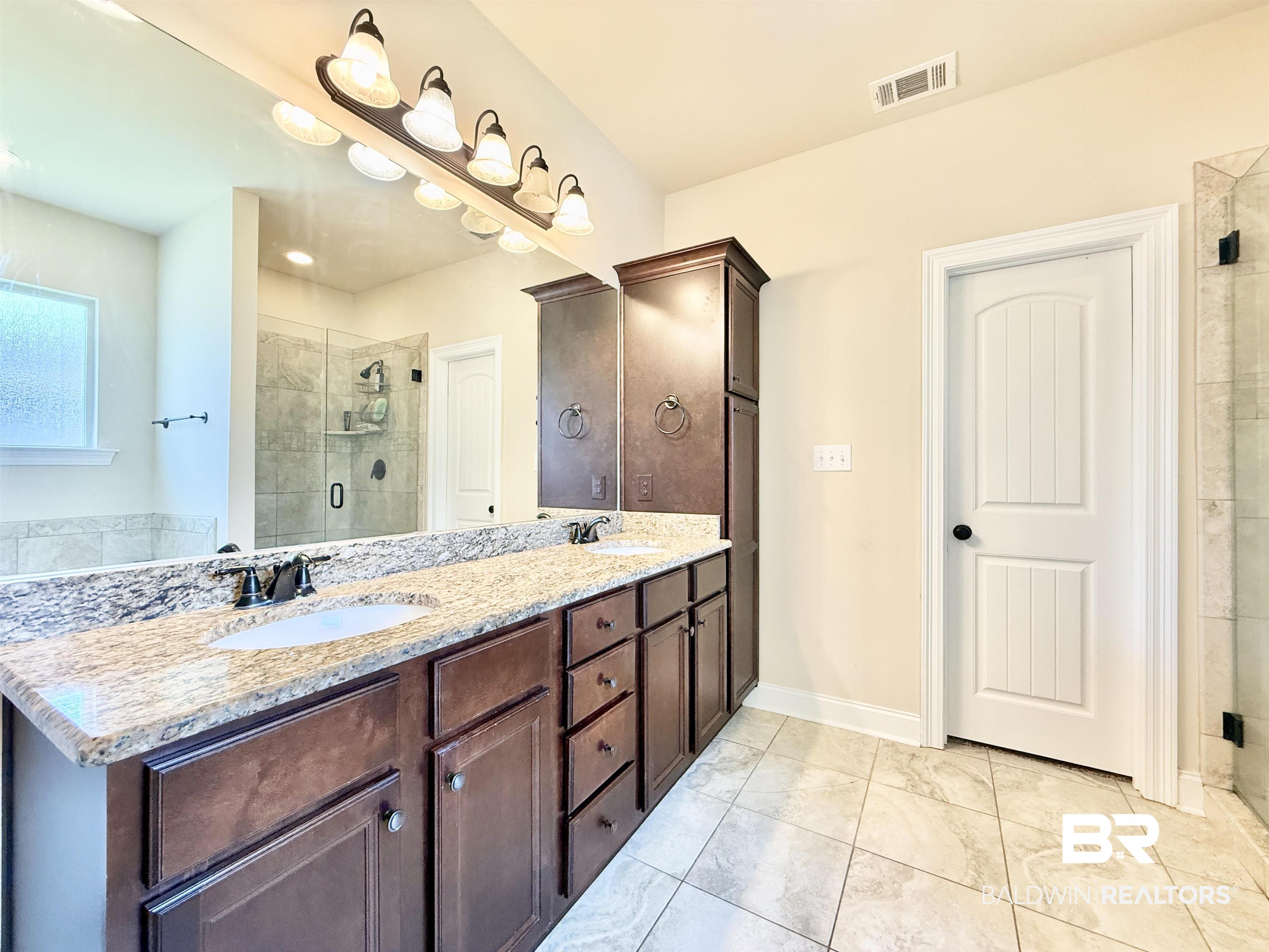 7011 Rocky Rd Loop Gulf Shores, AL 36542 - Photo 29 of 66 Bathroom with a shower stall and double vanity